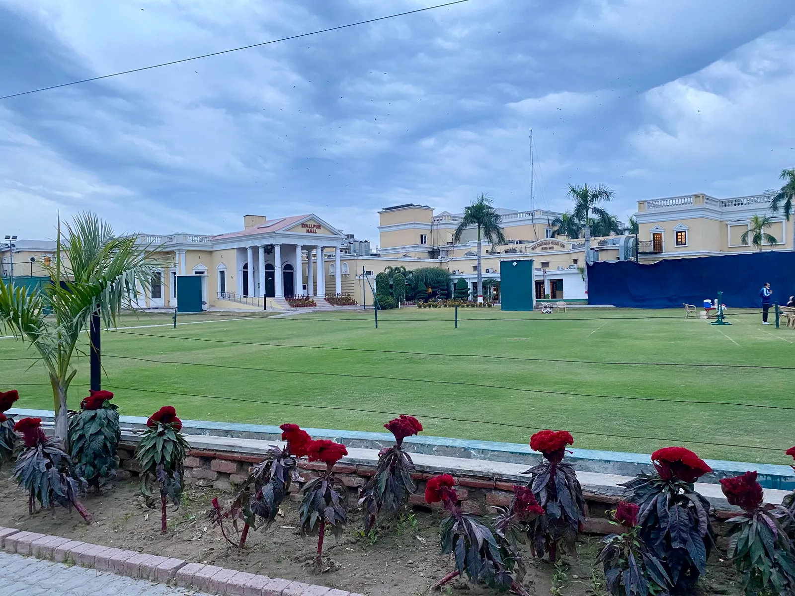 Chenab Club lawns and colonial building in Faisalabad under a cloudy sky