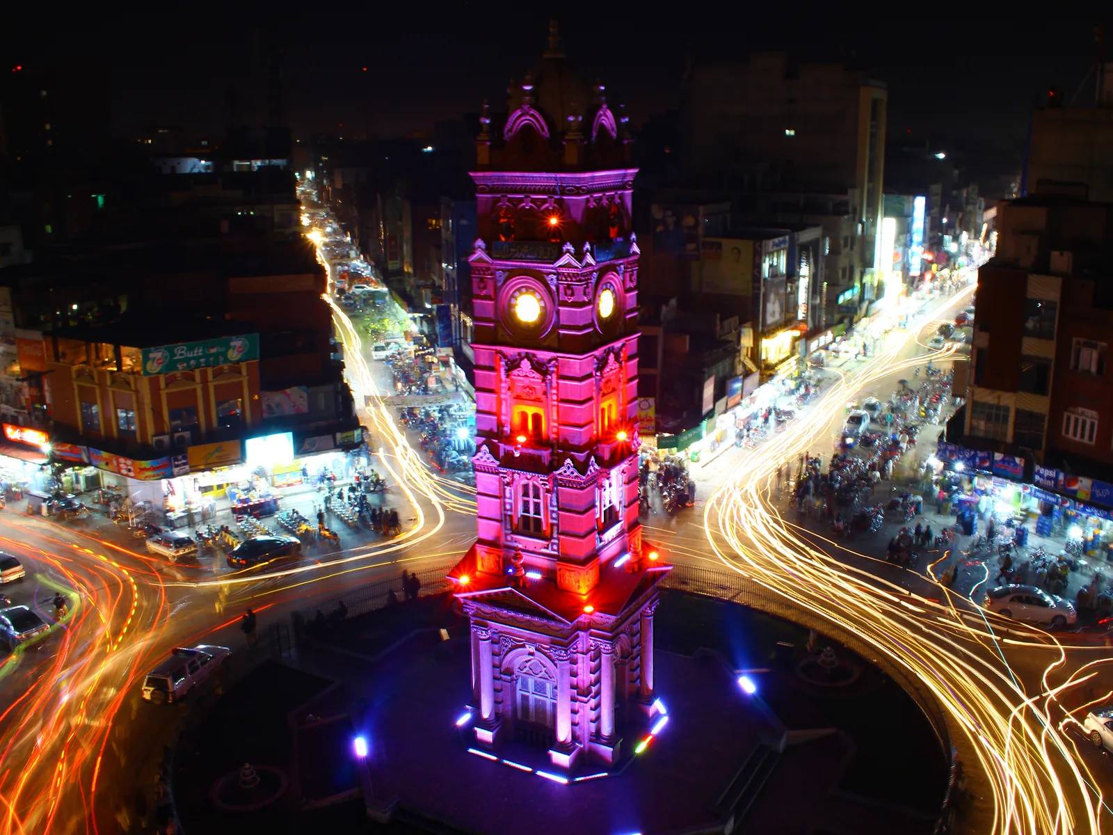Faisalabad Clock Tower lit at night with traffic light trails through the eight bazaars